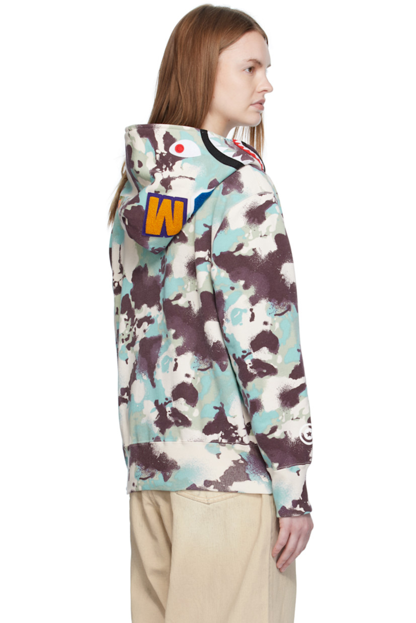 French terry hoodie.

· Logo camouflage pattern printed throughout
· Printed graphic and graphic appliqués at hood
· Two-way zip closure extends to hood
· Patch pockets at front
· Rib-knit hem and cuffs
· Logo flag at cuff

Supplier color: Multi