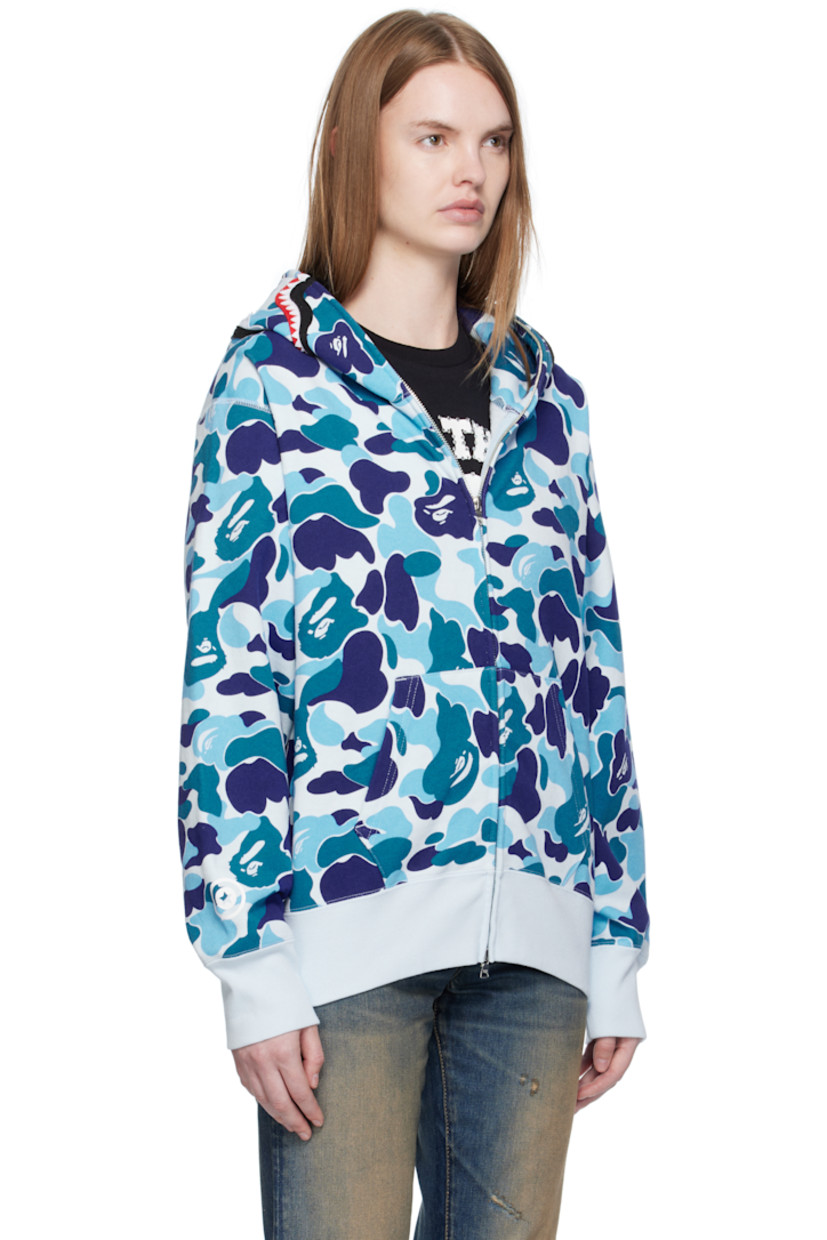 Cotton fleece hoodie.

· Logo camouflage pattern printed throughout
· Printed graphic and graphic appliqués at hood
· Two-way zip closure extends to hood
· Patch pockets at front
· Rib-knit hem and cuffs
· Logo flag at cuff

Supplier color: Blue