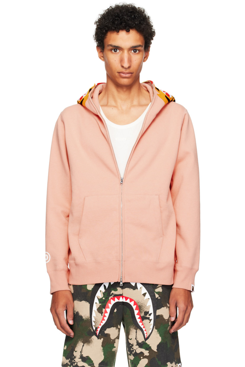 Cotton fleece hoodie. 

· Graphic patches and embroidered text at hood
· Graphics printed at hood and sleeves
· Two-way zip closure extends to hood
· Patch pockets
· Rib-knit hem and cuffs
· Dropped shoulders
· Logo flag at cuff

Supplier color: Pink