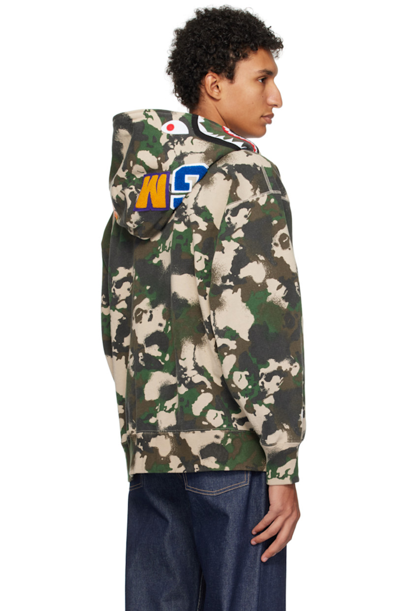 French terry hoodie. 

· Logo camouflage pattern throughout
· Printed graphic and graphic appliqués at hood
· Two-way zip closure extends to hood
· Patch pockets
· Rib-knit hem and cuffs
· Dropped shoulders
· Logo flag at cuff

Supplier color: Green