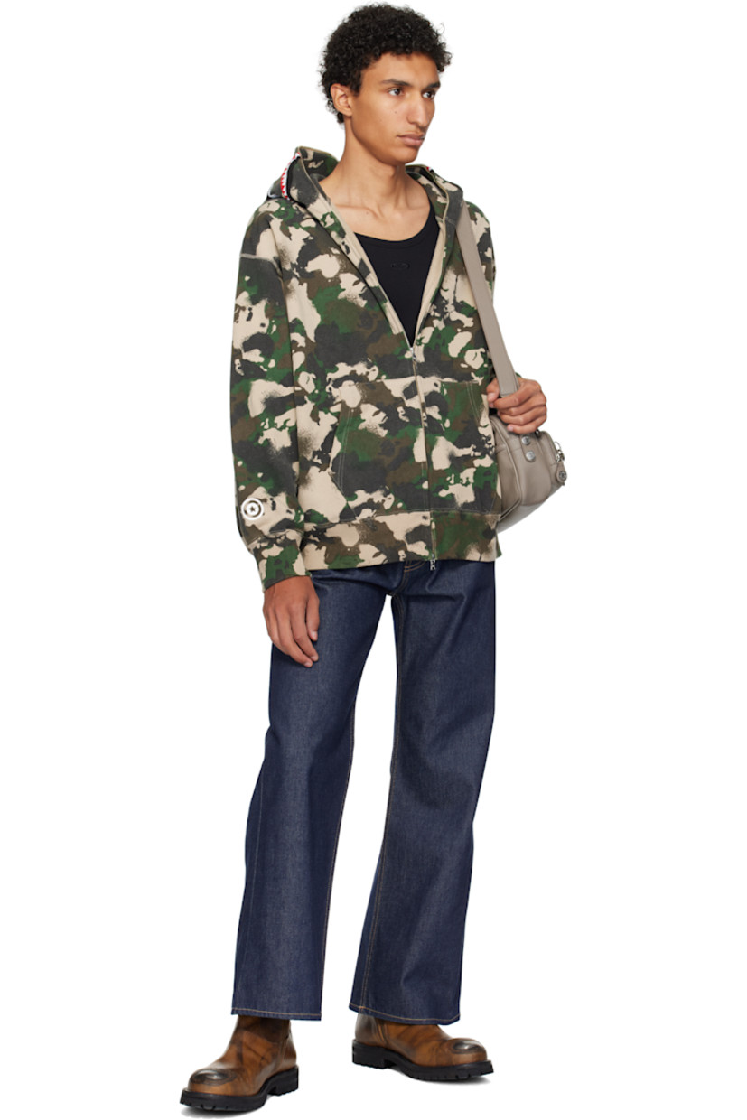 French terry hoodie. 

· Logo camouflage pattern throughout
· Printed graphic and graphic appliqués at hood
· Two-way zip closure extends to hood
· Patch pockets
· Rib-knit hem and cuffs
· Dropped shoulders
· Logo flag at cuff

Supplier color: Green