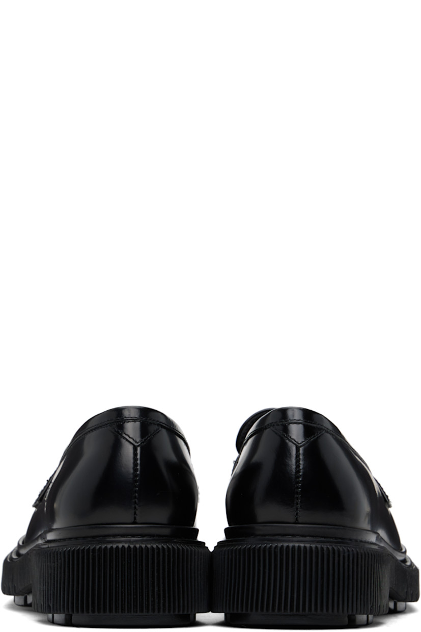 Polished leather loafers in black. 

· Moc toe
· Strap with cutout at vamp
· Logo printed at padded leather footbed
· Buffed leather and suede lining
· Topstitching at welt
· Textured rubber midsole
· Treaded rubber sole

Supplier color: Black