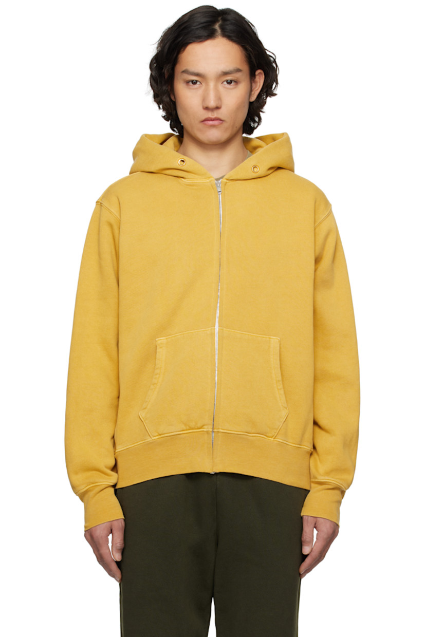 Heavyweight brushed cotton fleece hoodie.

· Preshrunk and garment-dyed
· Eyelets at hood
· Zip closure
· Patch pockets
· Rib-knit hem and cuffs
· Jersey gusset at side seams
· Dropped shoulders

Supplier color: Washed desert gold