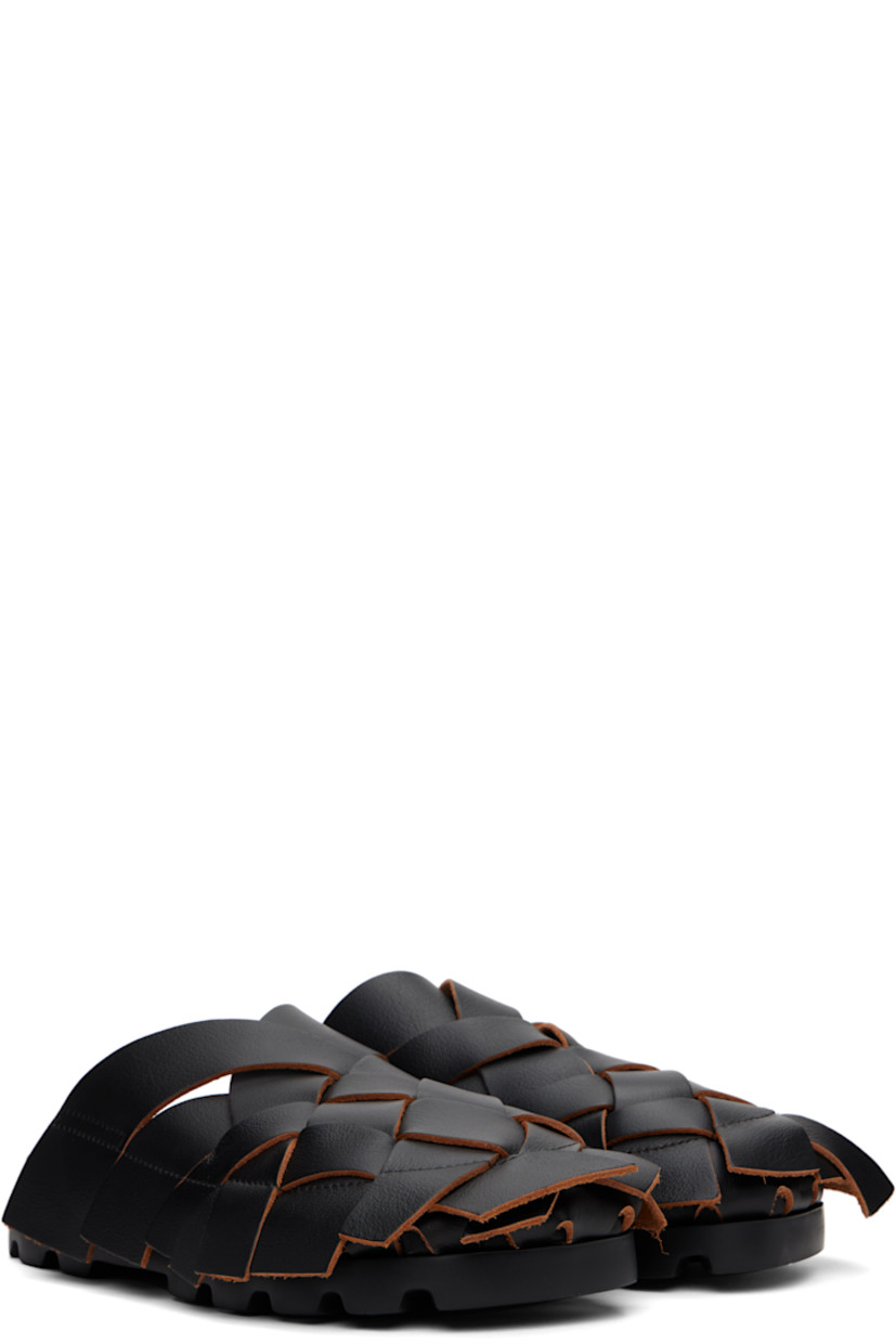 Basket-woven grained leather slip-on sandals in black.

· Extended trim with raw edges throughout
· Suede lining
· Logo printed at faux-leather footbed
· Treaded XL EXTRALIGHT® foam rubber sole

Supplier color: Merco negro/Brutus sand