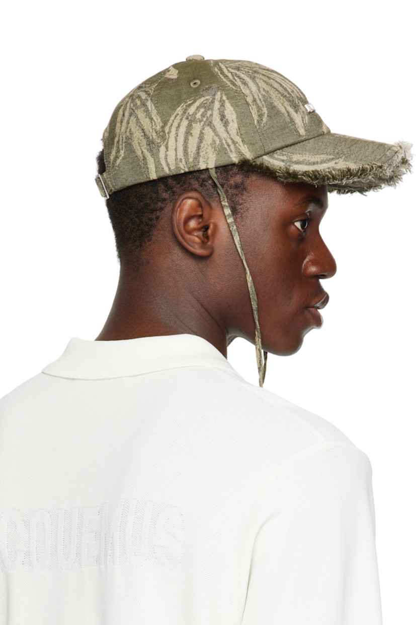 Cotton canvas cap in khaki.

· Jacquard graphic pattern throughout
· Embroidered eyelets at crown
· Logo hardware at face
· Frayed edge at curved brim
· Cord-lock chin strap
· Cinch fastening
· Logo-engraved silver-tone hardware

Supplier color: Jacquard banana logo/Khaki