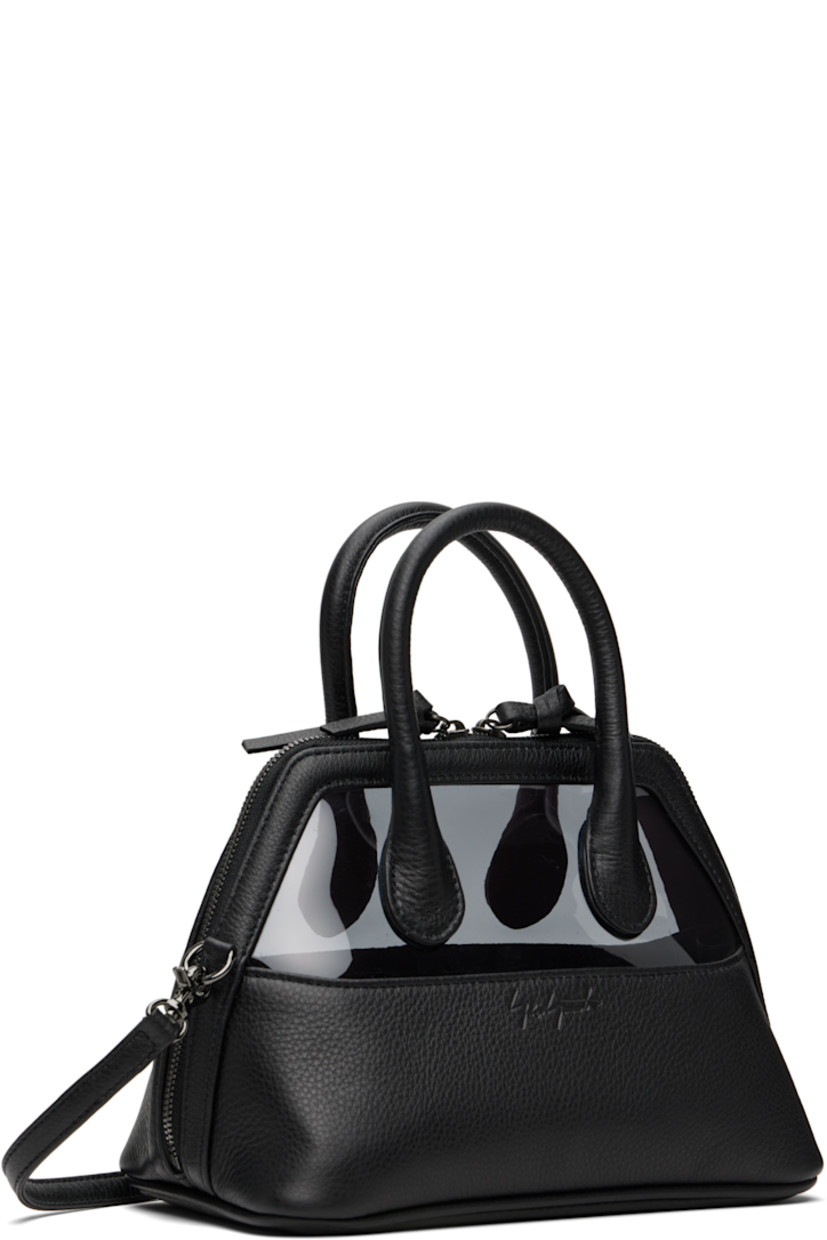 Grained leather top handle bag.

· Rolled carry handles
· Adjustable and detachable crossbody strap
· Logo embossed at face
· Transparent vinyl panel at face and back face
· Two-way zip closure
· Two card slots and one patch pocket at interior
· Twill lining
· H10" x W8" x D5.5"

Part of the discord YOHJI YAMAMOTO collection.

Supplier color: Black