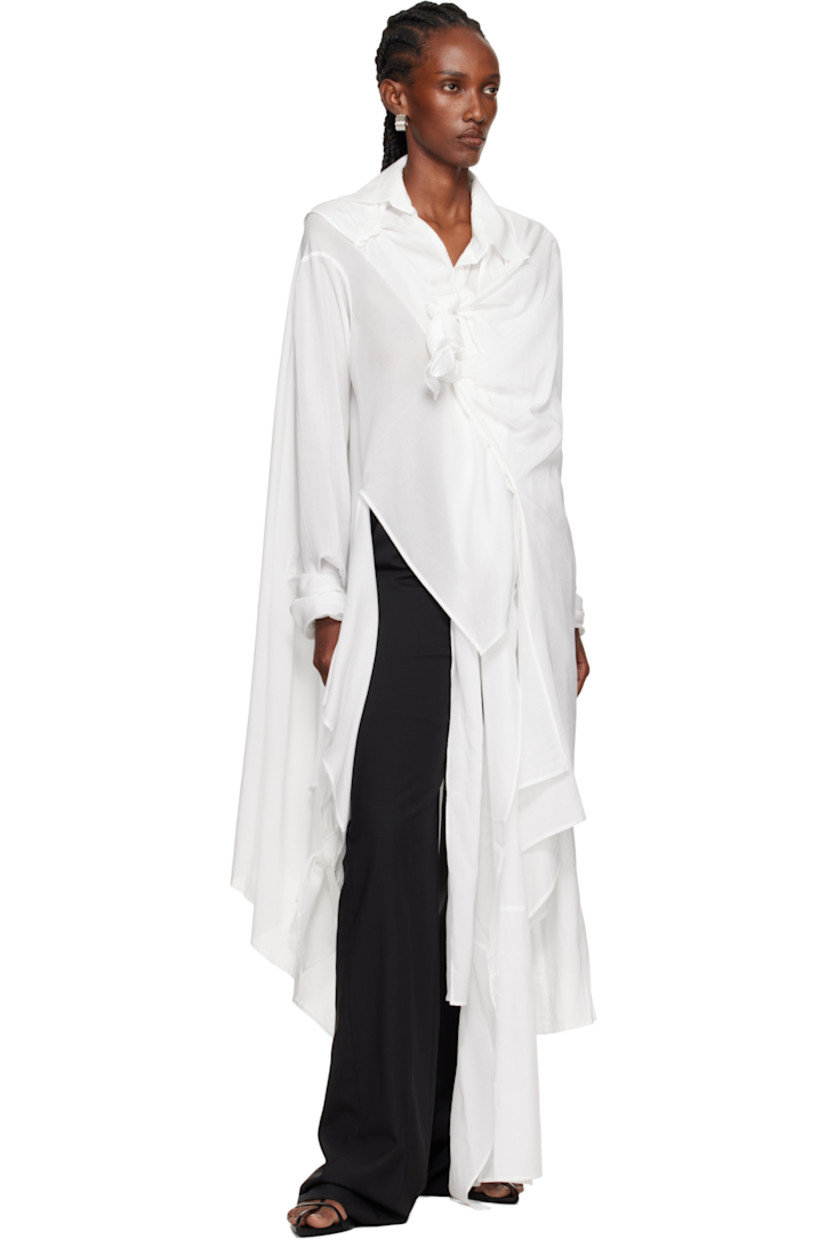 Cellulose poplin blouse.

· Draped construction
· Spread collar
· Self-tie knotted detailing at press-stud closure
· Handkerchief hem
· Self-tie fastening at cuffs

Supplier color: White