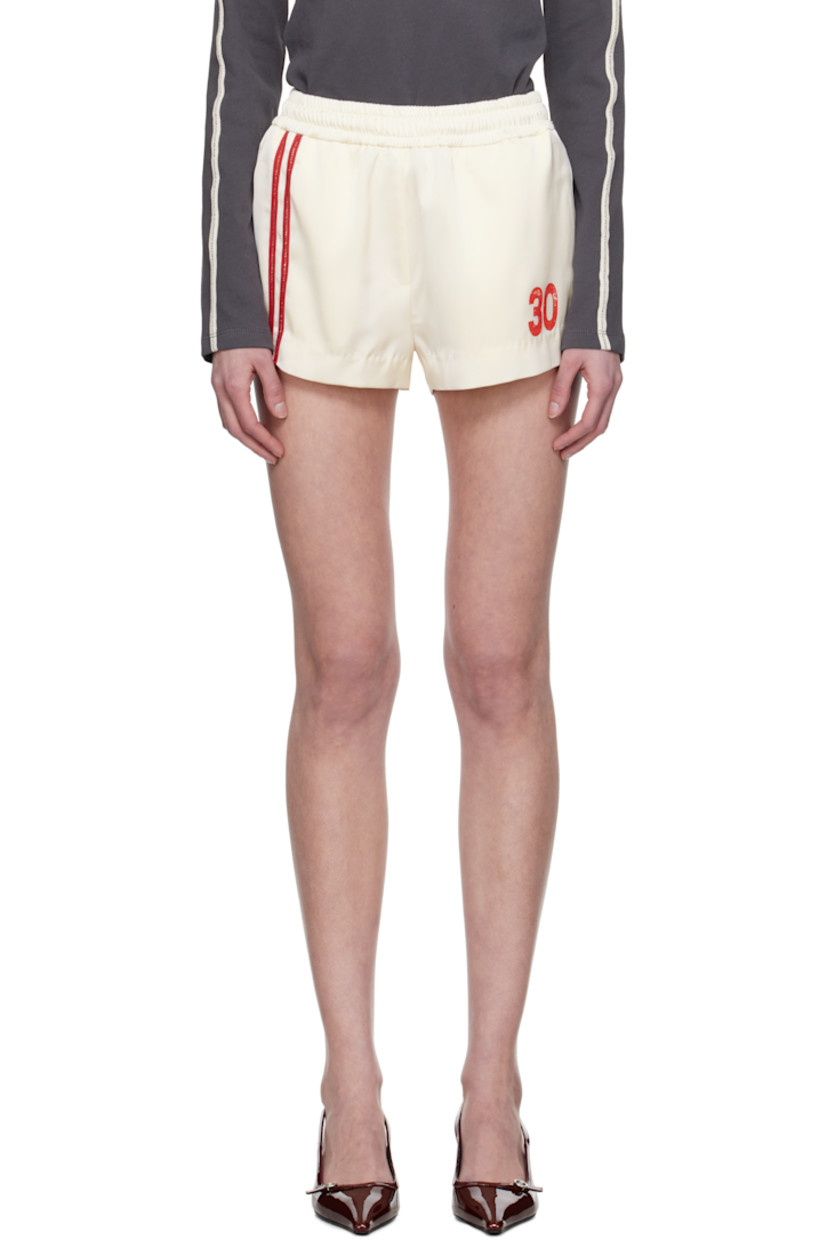 Polyester satin shorts.

· Concealed drawstring at elasticized waistband
· Three-pocket styling
· Stripe appliqués at front
· Text printed at leg

Supplier color: Ivory