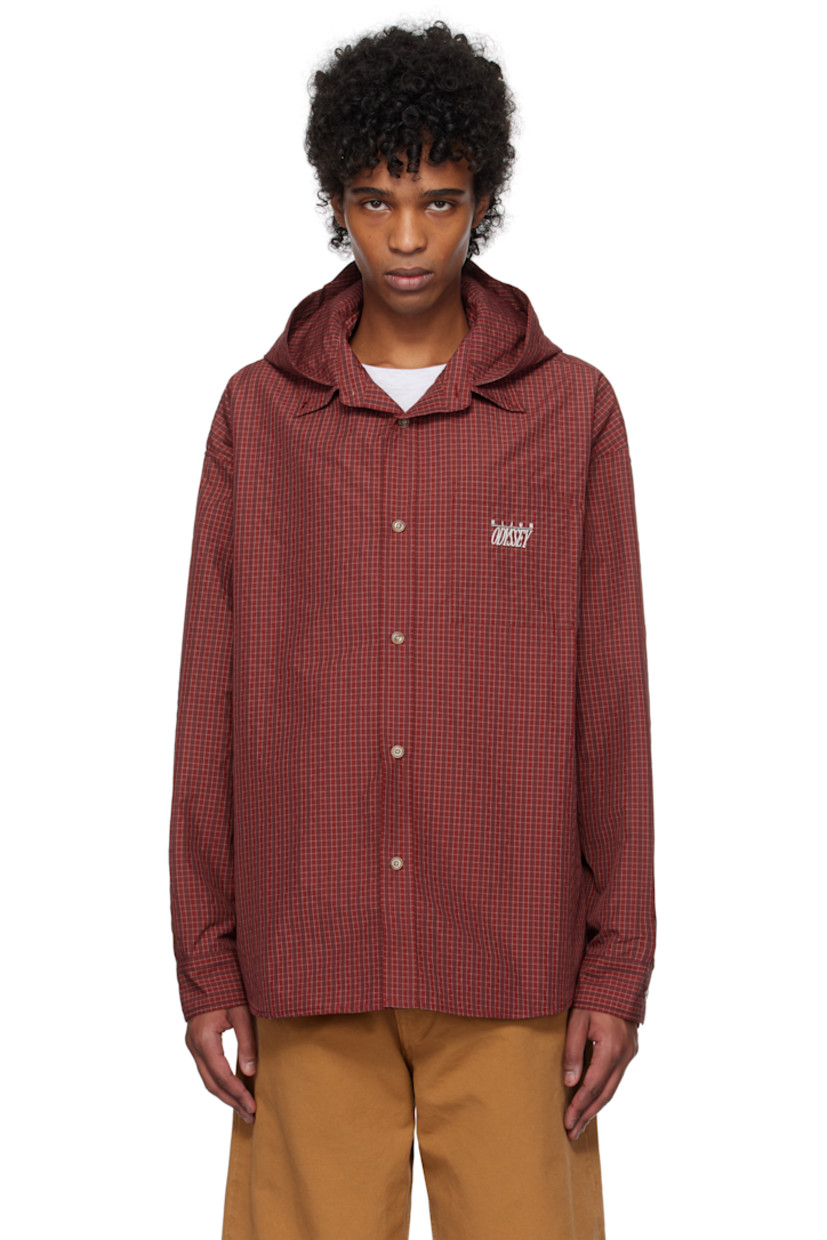Polyester twill shirt. Check pattern throughout.

· Hood at open spread collar
· Button closure
· Logo and text embroidered at patch pocket
· Shirttail hem
· Dropped shoulders
· Pleat at single-button barrel cuffs
· Locker loop at back collar
· Twin pleats at back yoke

Supplier color: Red