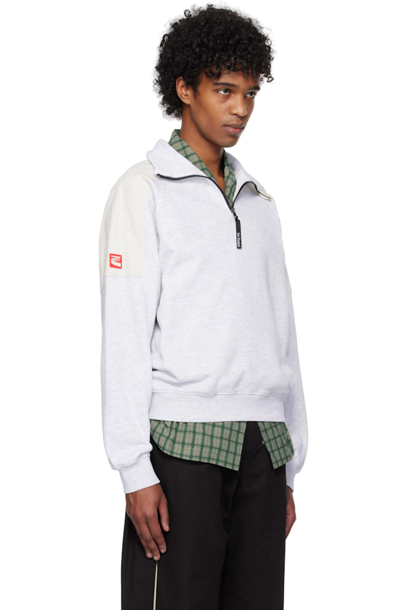 French terry sweatshirt. Twill patches throughout.

· Mock neck
· Half-zip closure
· Rib-knit hem and cuffs
· Raglan sleeves
· Rubberized logo patch at sleeve

Supplier color: Melange/White