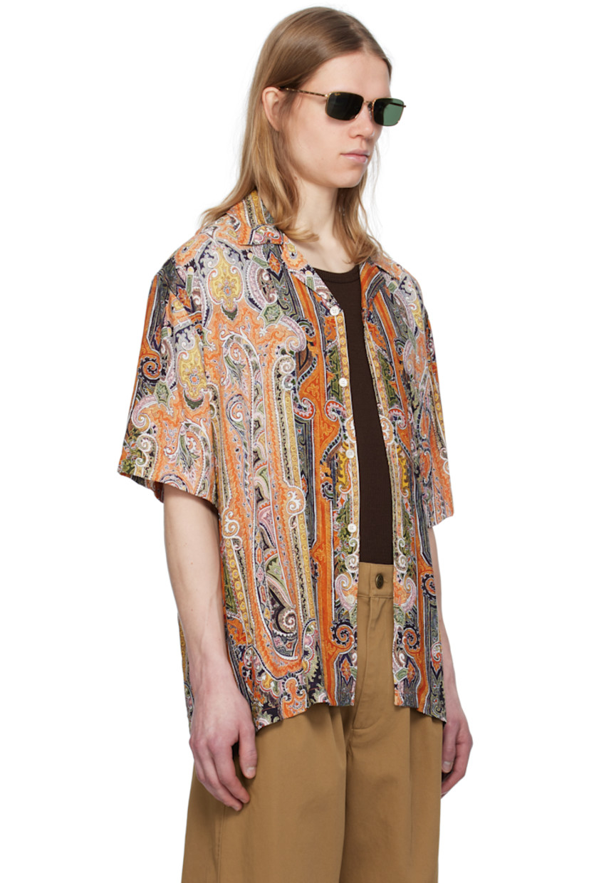 Plain-woven viscose shirt. Paisley pattern printed throughout. 

· Open spread collar 
· Button closure 
· Patch pocket at chest 
· Vent at side seams
· Dropped shoulders 
· Twin-pleats at back yoke 
· Mother-of-pearl hardware 

Supplier color: Burnt orange