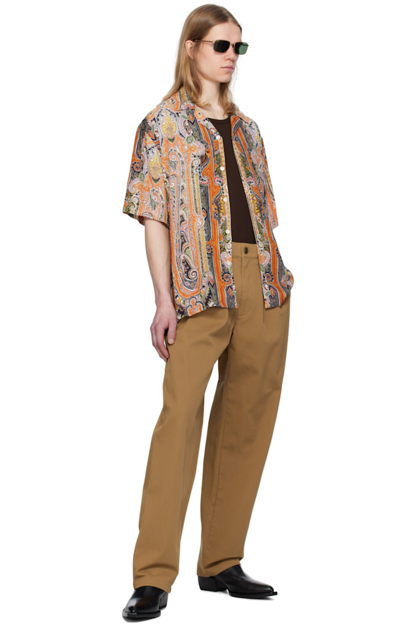 Plain-woven viscose shirt. Paisley pattern printed throughout. 

· Open spread collar 
· Button closure 
· Patch pocket at chest 
· Vent at side seams
· Dropped shoulders 
· Twin-pleats at back yoke 
· Mother-of-pearl hardware 

Supplier color: Burnt orange