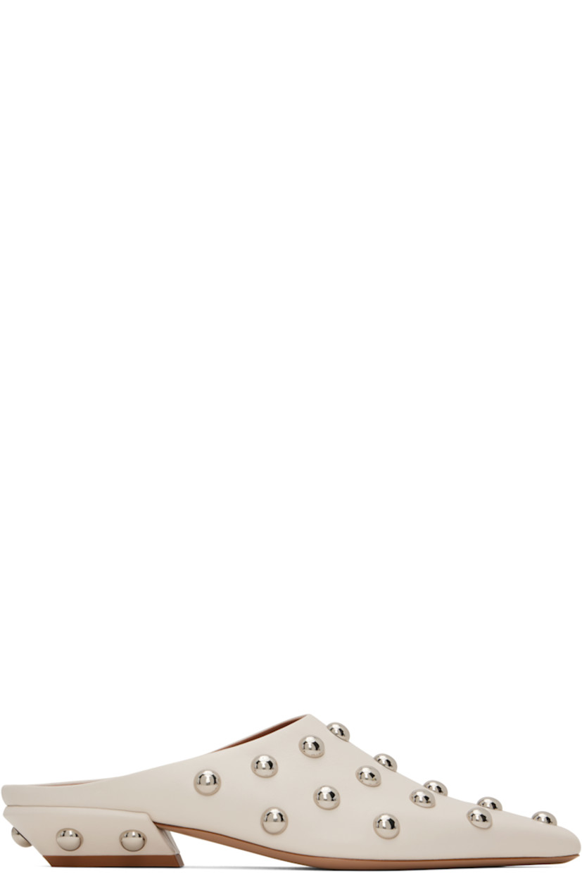 Grained calfskin slip-on loafers in beige.  

· Studs throughout
· Pointed square toe 
· Logo stamp at padded footbed
· Grained leather lining 
· Block heel with rubber injection
· Leather sole 
· Silver-tone hardware
· Heel: H1"

Supplier color: Milk