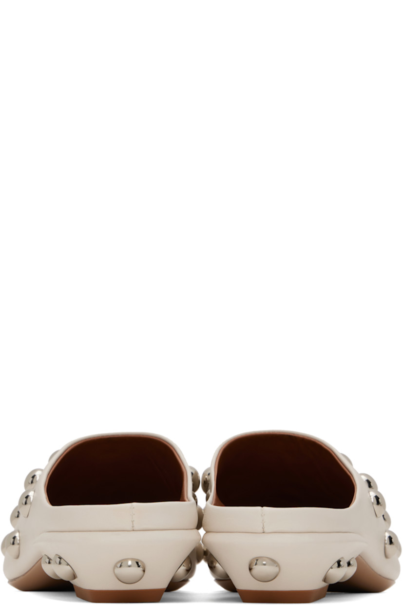 Grained calfskin slip-on loafers in beige.  

· Studs throughout
· Pointed square toe 
· Logo stamp at padded footbed
· Grained leather lining 
· Block heel with rubber injection
· Leather sole 
· Silver-tone hardware
· Heel: H1"

Supplier color: Milk