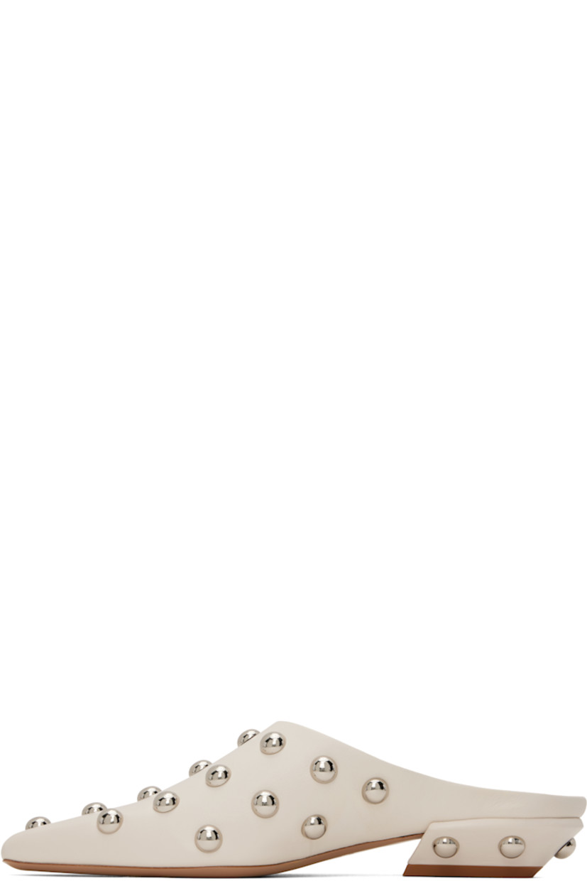 Grained calfskin slip-on loafers in beige.  

· Studs throughout
· Pointed square toe 
· Logo stamp at padded footbed
· Grained leather lining 
· Block heel with rubber injection
· Leather sole 
· Silver-tone hardware
· Heel: H1"

Supplier color: Milk