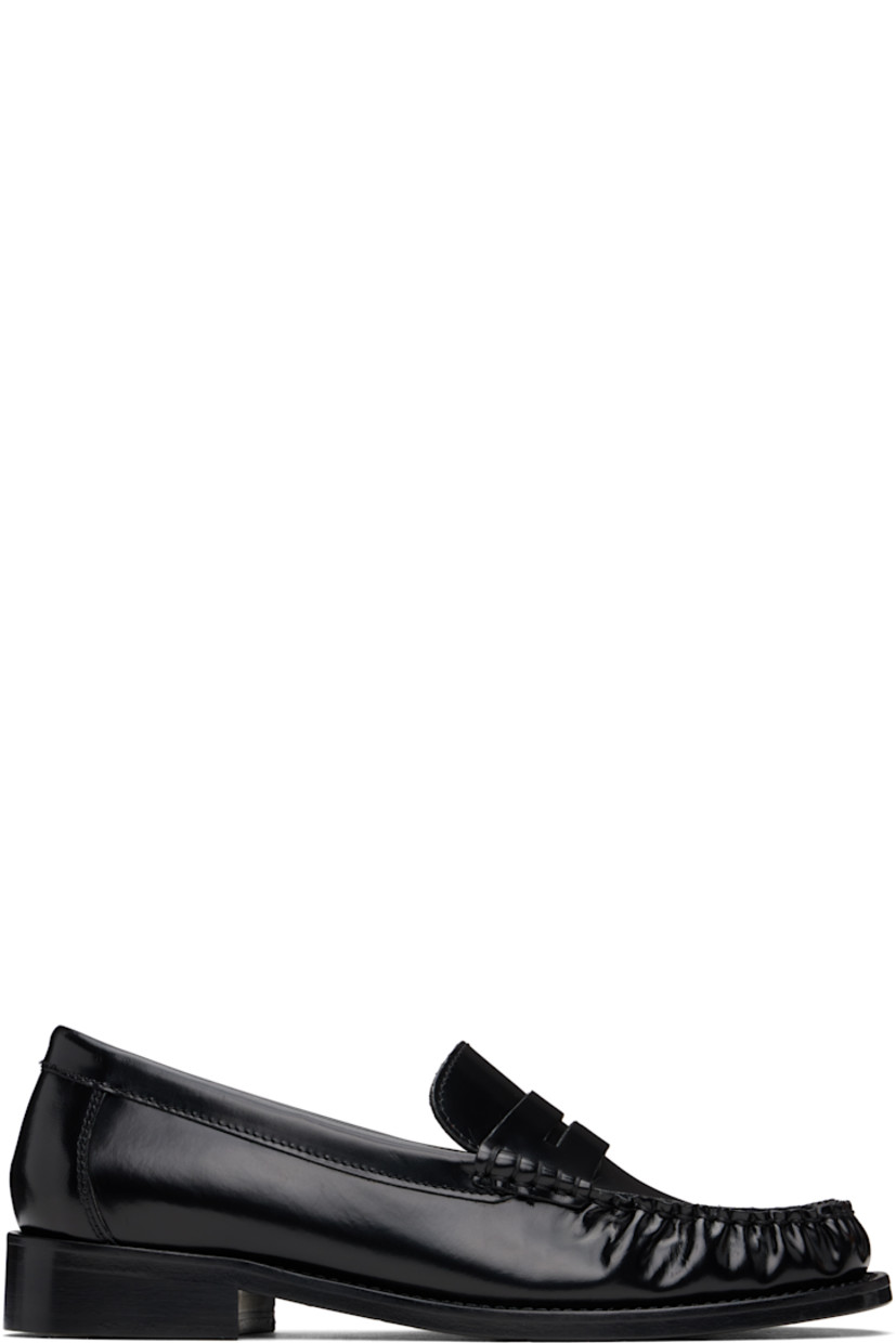 Brushed calfskin loafers in black.

· Moc toe
· Strap with cutout at vamp
· Suede and buffed calfskin lining
· Stacked leather heel with rubber injection
· Leather sole with rubber injection

Supplier color: Black