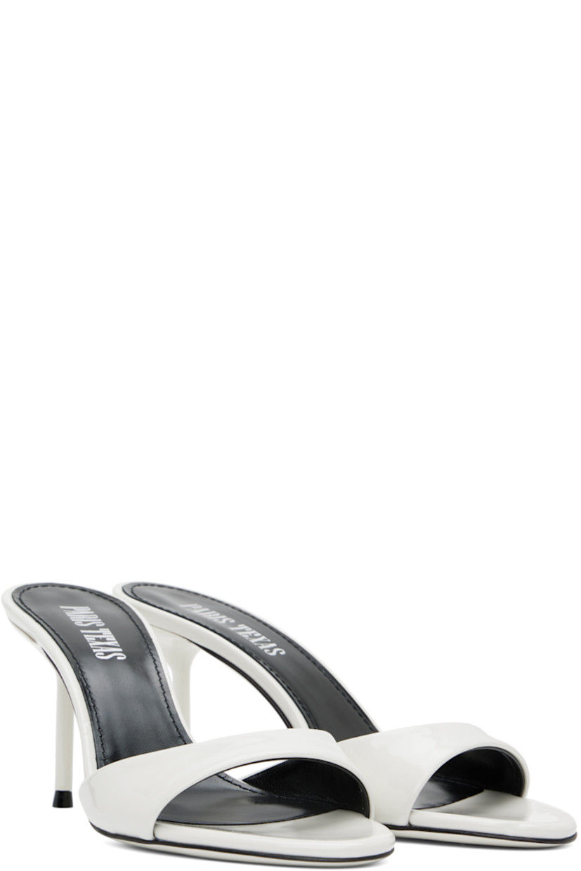 Patent leather mules in white.

· Open toe
· Strap at vamp
· Logo stamp at padded leather footbed
· Metal stiletto heel with rubber injection
· Patent leather sole
· Heel: H3"

Supplier color: White