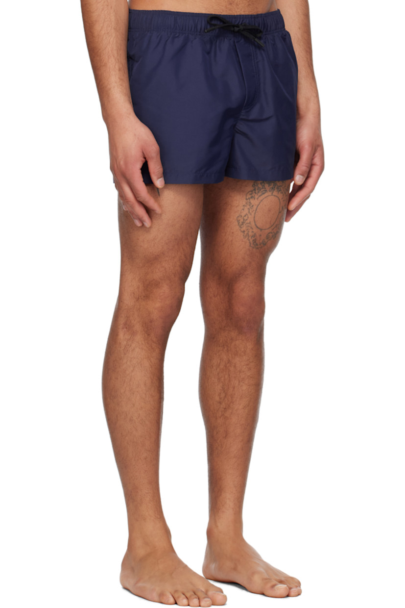 Polyester taffeta swim shorts. 

· Drawstring at elasticized waistband
· Three-pocket styling
· Mock fly
· Embroidered Medusa patch at front
· Integrated brief-style mesh lining

Supplier color: Ink blue