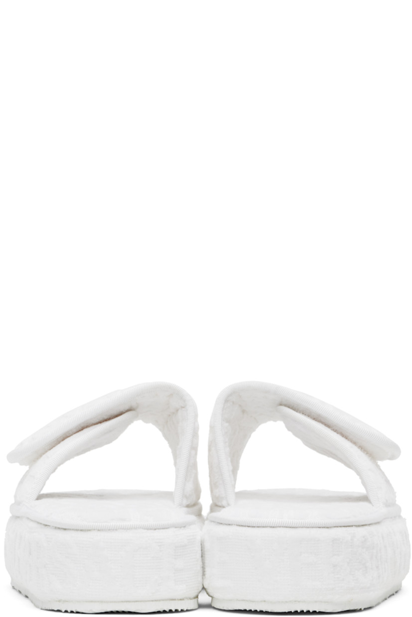 Cotton terrycloth slippers in white.

· Logo pattern flocked throughout
· Open toe
· Logo-embroidered velcro strap at vamp
· Covered platform midsole
· Treaded rubber outsole
· Platform: H2"

Supplier color: White