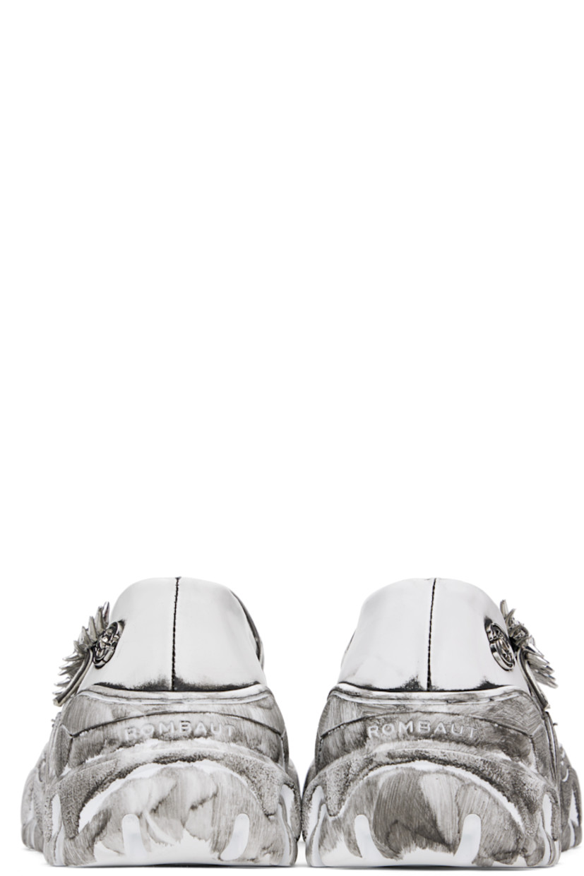 Buffed faux-leather Mary Jane-style loafers in white.

· Bureau Veritas-certified faux-leather
· Smudging throughout
· Partially elasticized pin-buckle straps
· Logo hardware at outer side
· Logo embossed at heel
· Grained faux-leather lining
· Sculptural platform rubber midsole
· Treaded rubber sole
· Silver-tone graphic hardware
· Platform: H1.5"

Supplier color: Quantum