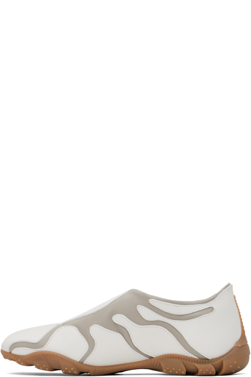 Low-top buffed faux-leather slip-on sneakers in white and gray.

· Faux-leather appliqués throughout
· Padded faux-leather logo patch at vamp 
· Padded collar
· Logo embossed at heel
· Spikes at rubber midsole
· Treaded rubber sole

Supplier color: Grey/White