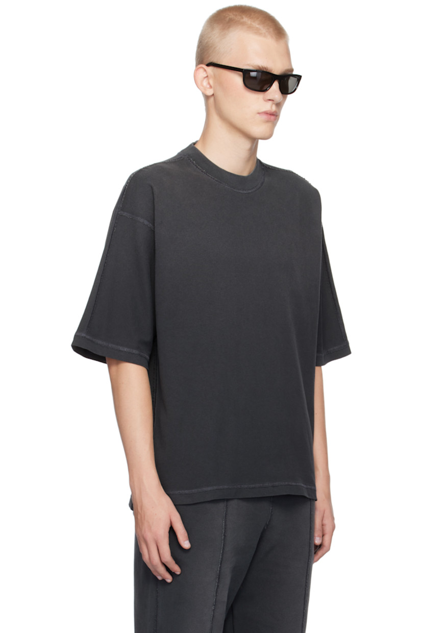 Oversized cotton jersey T-shirt. Exposed seams, fading, and distressing throughout.

· Rib-knit crewneck
· Tennis-tail hem
· Logo flag at side seam
· Dropped shoulders
· Jersey appliqué at back collar

Supplier color: Stained black