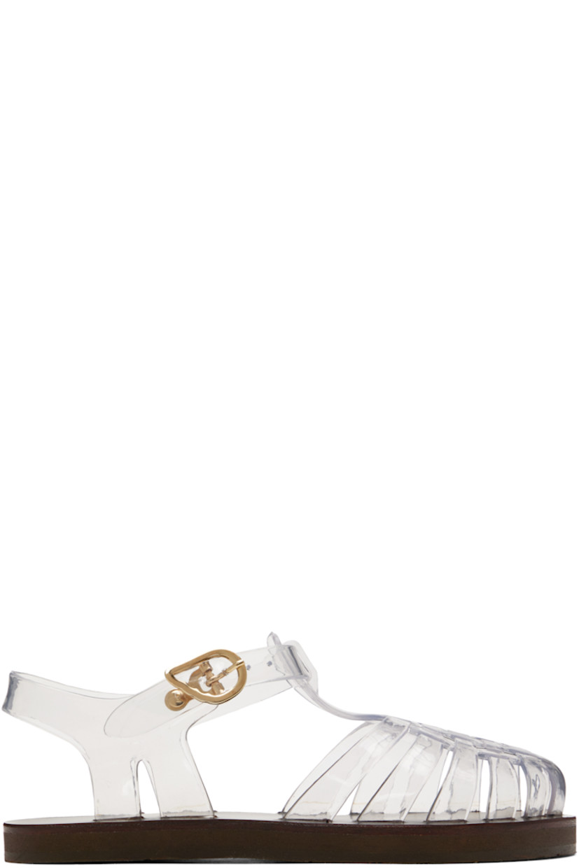 Handcrafted transparent vinyl flat sandals.

· Cutouts throughout
· Logo hardware at pin-buckle ankle strap
· Hand-stitched stacked leather midsole
· Logo-embossed rubber sole

Supplier color: Clear