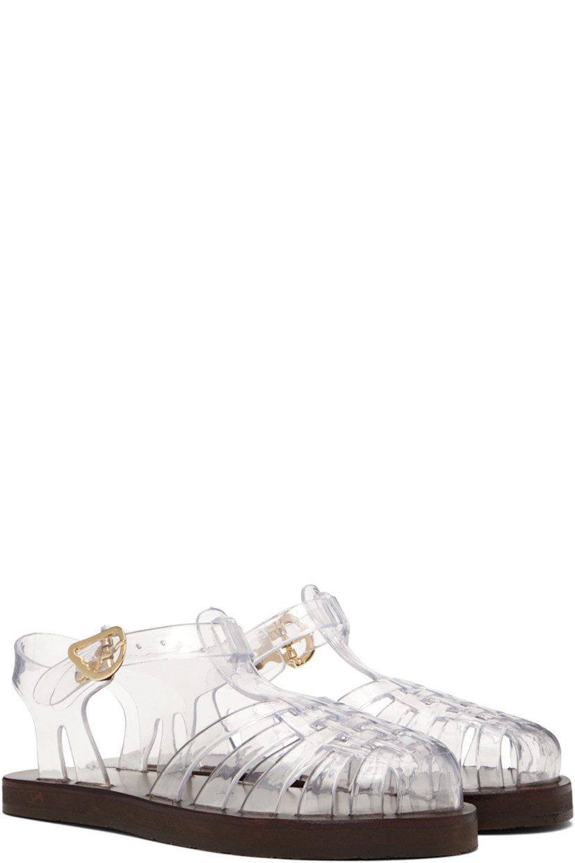 Handcrafted transparent vinyl flat sandals.

· Cutouts throughout
· Logo hardware at pin-buckle ankle strap
· Hand-stitched stacked leather midsole
· Logo-embossed rubber sole

Supplier color: Clear