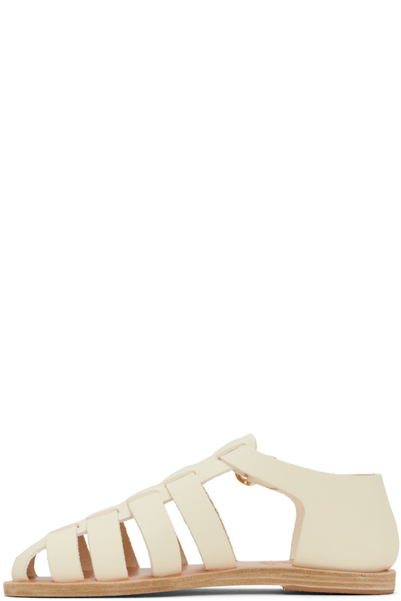Handcrafted buffed leather flat sandals in off-white.

· Cutouts throughout
· Pin-buckle ankle strap
· Logo embossed at footbed
· Leather sole with rubber injection

Supplier color: Off white