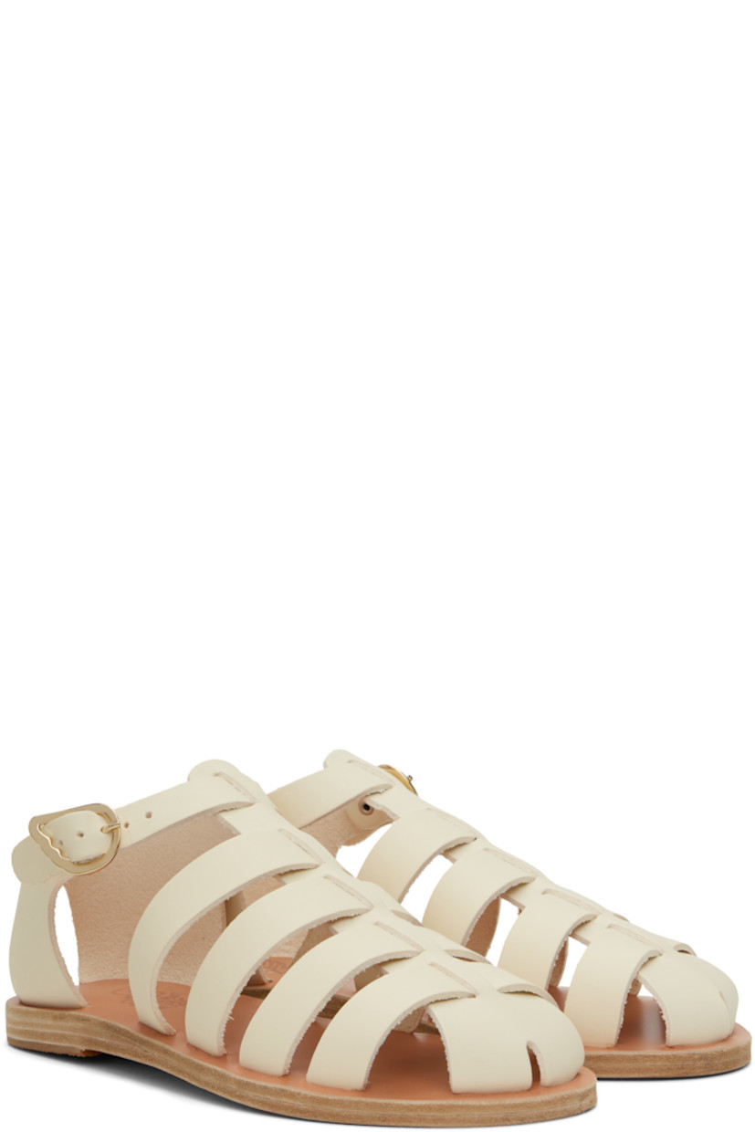 Handcrafted buffed leather flat sandals in off-white.

· Cutouts throughout
· Pin-buckle ankle strap
· Logo embossed at footbed
· Leather sole with rubber injection

Supplier color: Off white