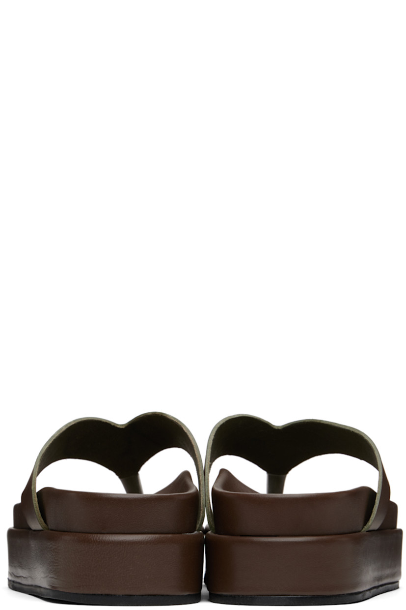 Handcrafted chemical-free buffed vachetta leather flip-flops in brown.

· Open toe
· Thong-style strap
· Logo embossed at molded footbed
· Treaded rubber platform sole
· Platform: H2"

Supplier color: Khaki