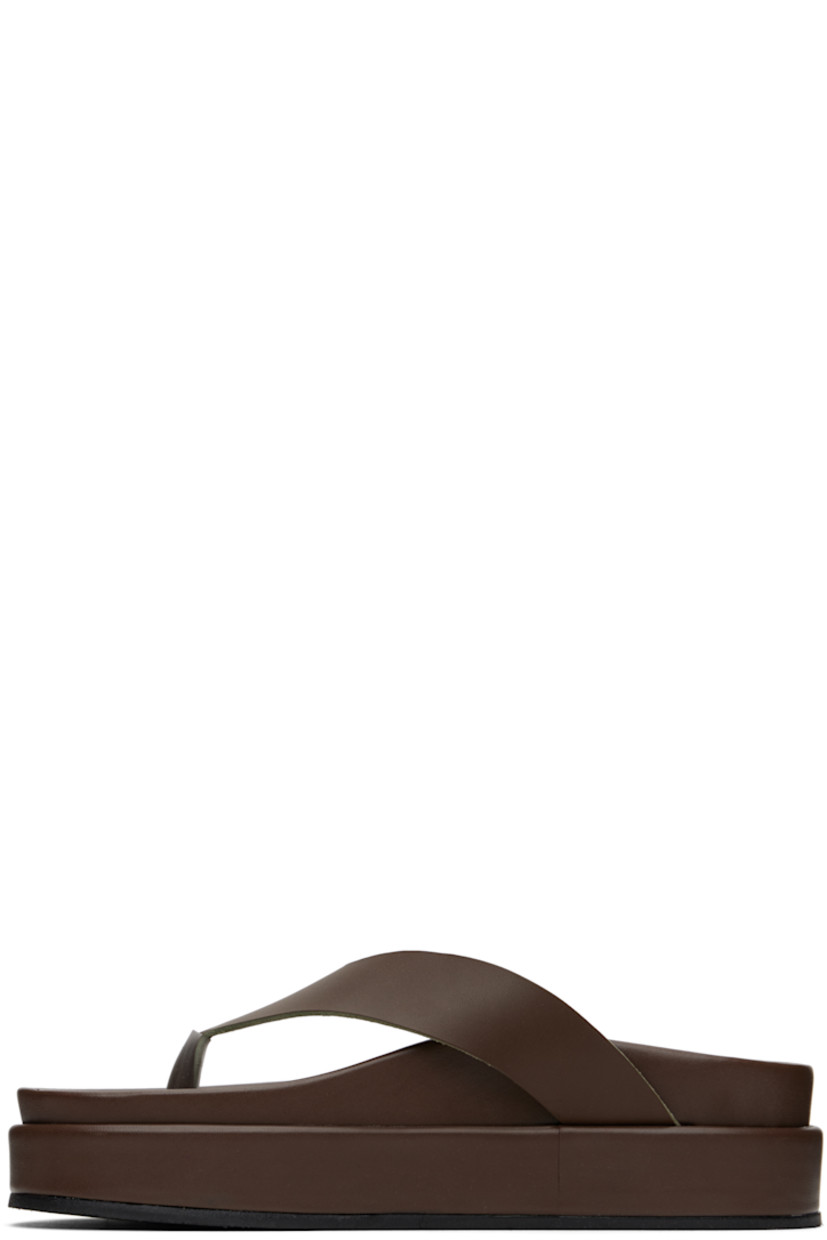 Handcrafted chemical-free buffed vachetta leather flip-flops in brown.

· Open toe
· Thong-style strap
· Logo embossed at molded footbed
· Treaded rubber platform sole
· Platform: H2"

Supplier color: Khaki
