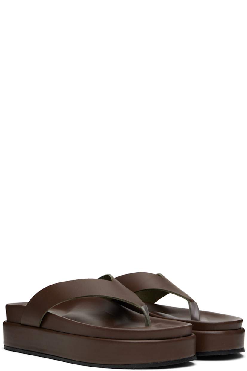 Handcrafted chemical-free buffed vachetta leather flip-flops in brown.

· Open toe
· Thong-style strap
· Logo embossed at molded footbed
· Treaded rubber platform sole
· Platform: H2"

Supplier color: Khaki