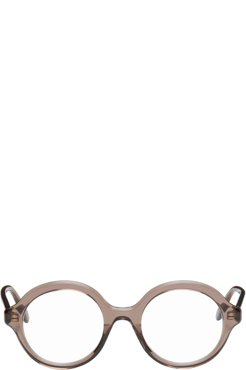 Round semi-transparent acetate-frame optical glasses in brown.

· Integrated nose pads
· Gold-tone logo stamp at temples
· Exposed core wire
· Includes pouch
· Size: 50.21 140

Supplier color: Dark brown/Other