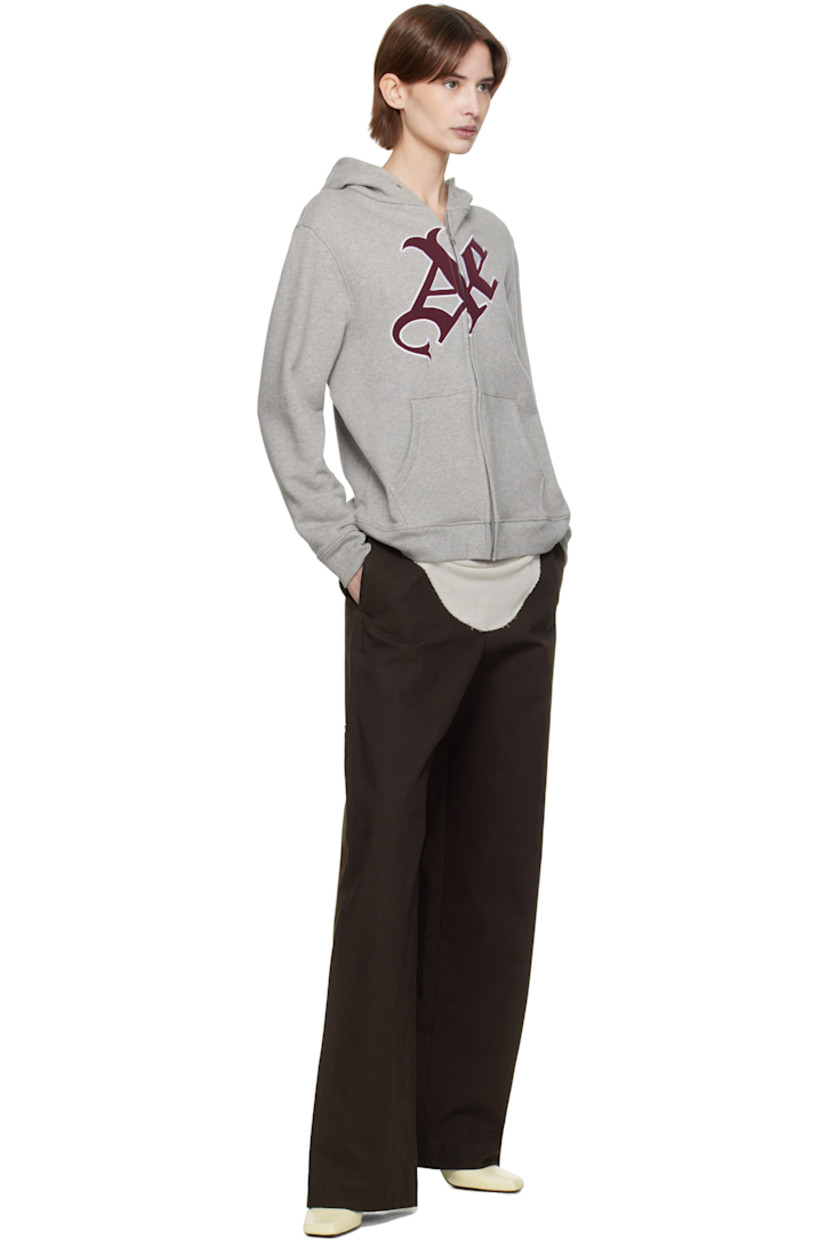 French terry hoodie.

· Eyelets at hood
· Zip closure
· Padded satin logo appliqué at front
· Patch pockets
· Rib-knit hem and cuffs

Supplier color: Grey