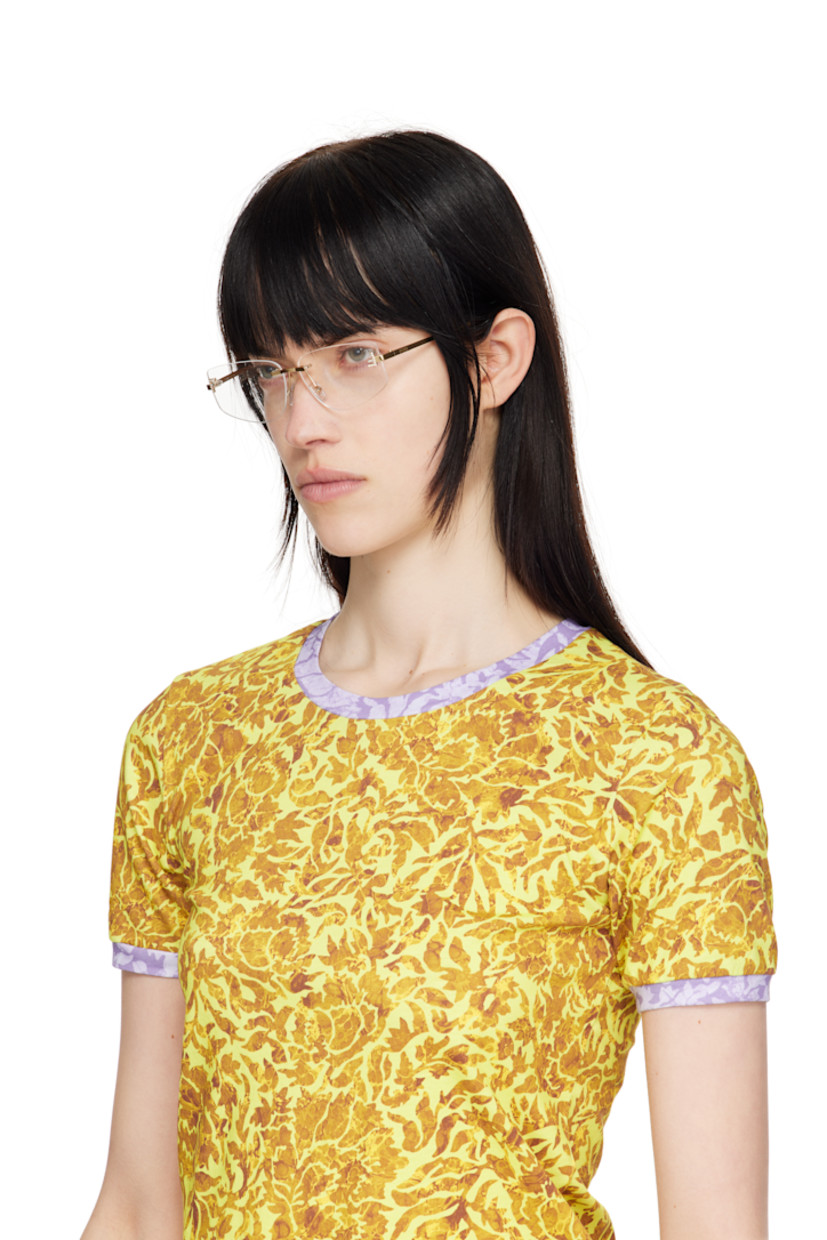 Cat-eye rimless metal-frame optical glasses in gold tone. 

· Adjustable rubber nose pads
· Crystal-cut logo at face 
· Logo embossed at temples
· Acetate temple tips in brown
· Includes pouch 
· Size: 58.12 135 

Supplier color: Shiny endura gold