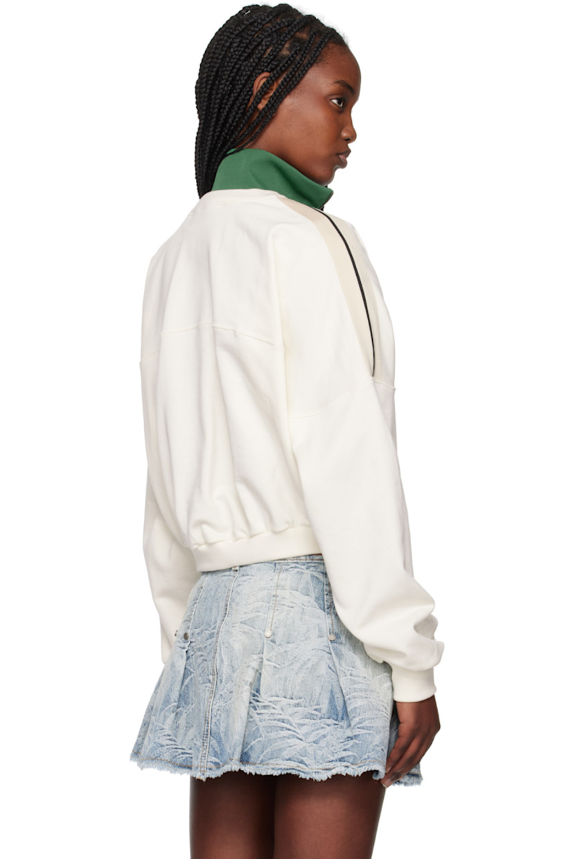 French terry and polyester interlock jersey sweatshirt. 

· Paneled construction
· Rib-knit stand collar, hem, and cuffs
· Half-zip closure
· Logo embroidered at chest
· Cropped hem
· Logo flag at side seam
· Striped trim at shoulders
· Yoke sleeves

Supplier color: Off white/Forest green