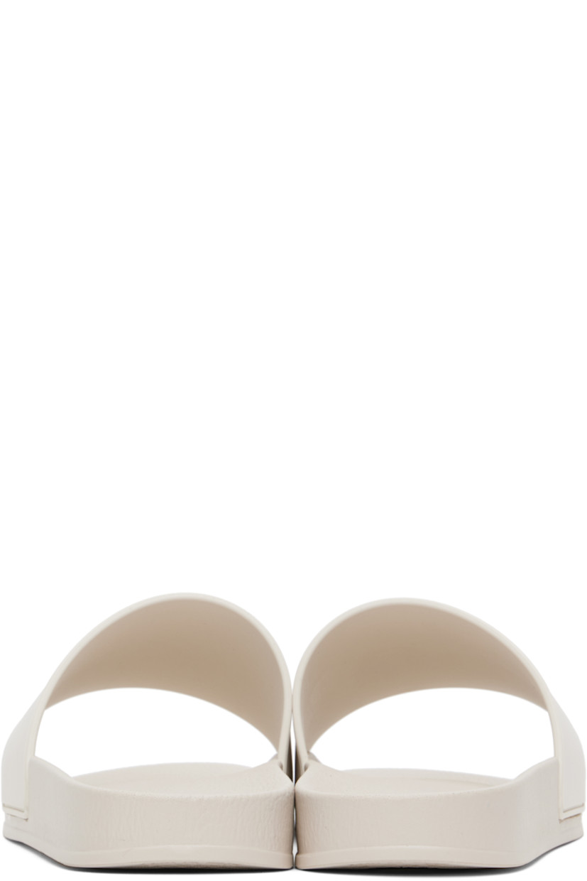 Rubber pool slides in beige.

· Open toe
· Logo embossed at vamp
· Logo embossed at molded footbed
· Treaded rubber sole

Supplier color: Beige/Black