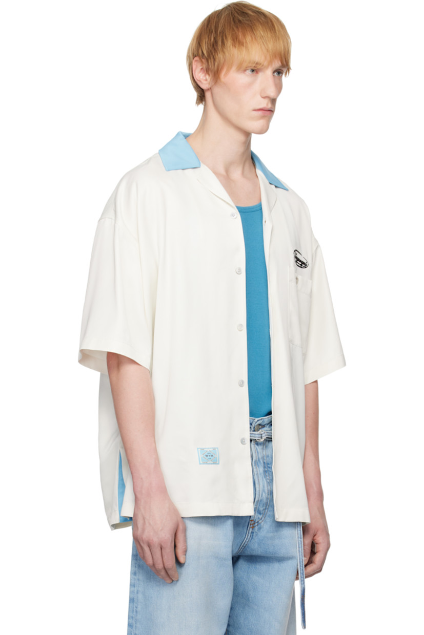 Viscose satin shirt.

· Open spread collar
· Button closure
· Logo embroidered at chest
· Patch pocket
· Logo patch at hem
· Dropped shoulders
· Vented side seams
· Logo hardware at back collar
· Twin pleats at back yoke
· Logo, graphic, and text embroidered at back

Supplier color: Ivory