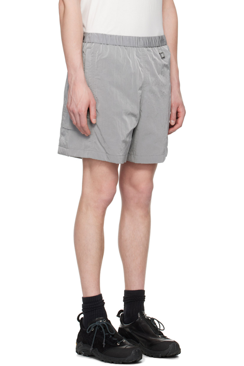 Crinkled nylon taffeta shorts. 

· Concealed bungee-style drawstring at elasticized waistband
· Three-pocket styling
· Logo hardware at waist and leg
· Flap pocket at outseams
· Logo flag at back waistband
· Full mesh lining

Supplier color: Gray