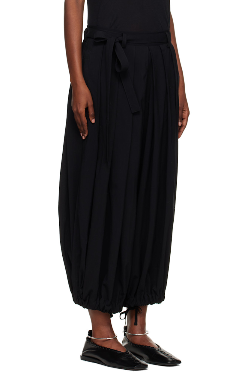 Wool twill trousers.

· Pleats throughout 
· Belt loops
· Integrated self-tie belt at elasticized waistband
· Single-pocket styling
· Zip fly 
· Dropped inseam
· Self-tie straps at elasticized cuffs

Supplier color: Black