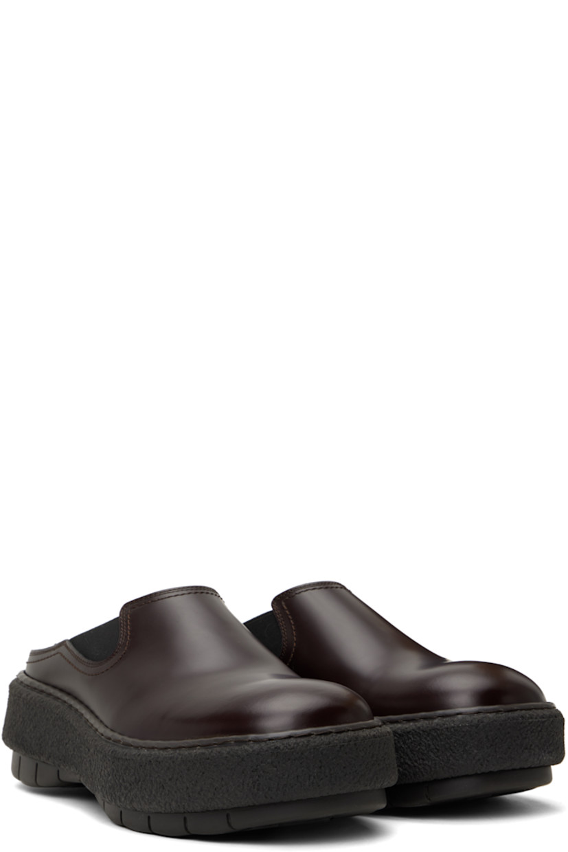 Polished leather slip-on loafers in brown.

· Square toe
· Elasticized gusset at sides
· Buffed leather lining
· Logo embossed at heel
· Crêpe rubber midsole
· Treaded rubber sole

Supplier color: Brown