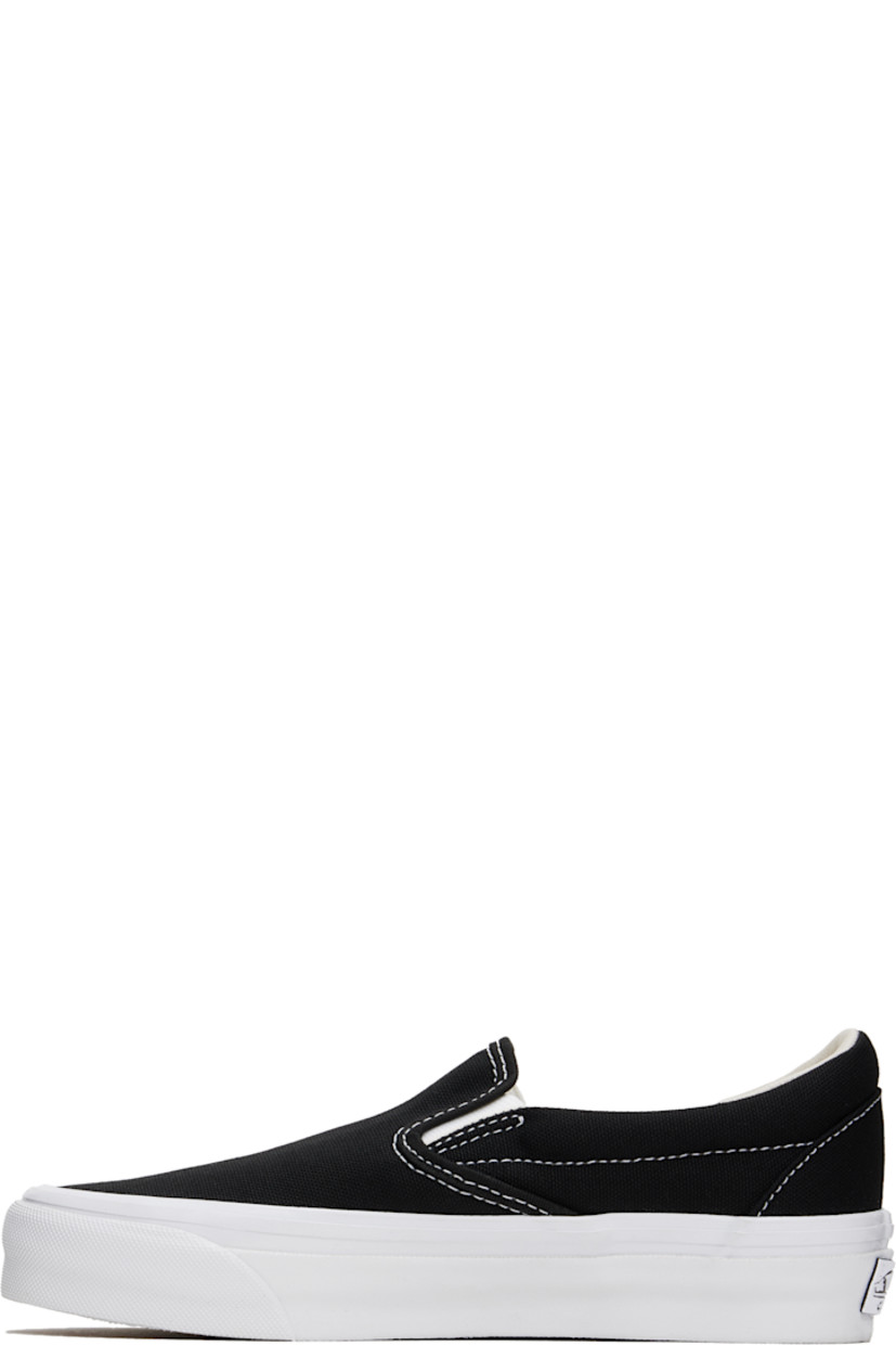 Low-top slip-on canvas sneakers in black. 

· Elasticized gussets at tongue
· Padded collar
· Logo flag at outer side
· Padded Sola ADC foam footbed
· Grained leather and canvas lining
· Rubberized logo patch at heel
· Treaded rubber sole
· Contrast stitching in white

Supplier color: Black/White