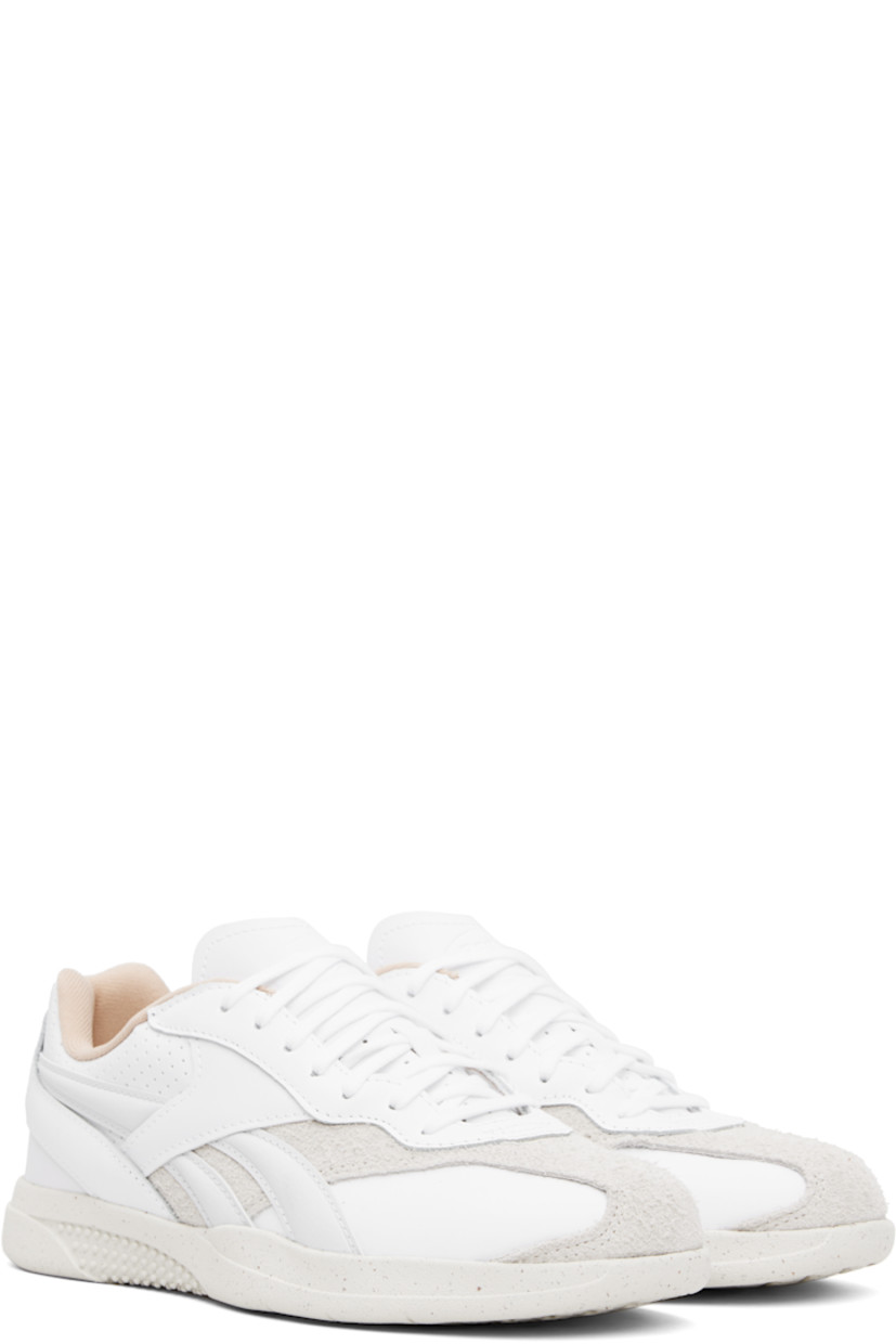 Low-top grained leather sneakers in white.

· Suede trim at toe and sides
· Lace-up closure
· Logo embossed at padded tongue
· Perforations at padded collar and heel
· Signature stripes at sides
· Logo embroidered at heel counter
· Jersey lining
· Textured treaded rubber sole

Supplier color: White/Chalk/Moon