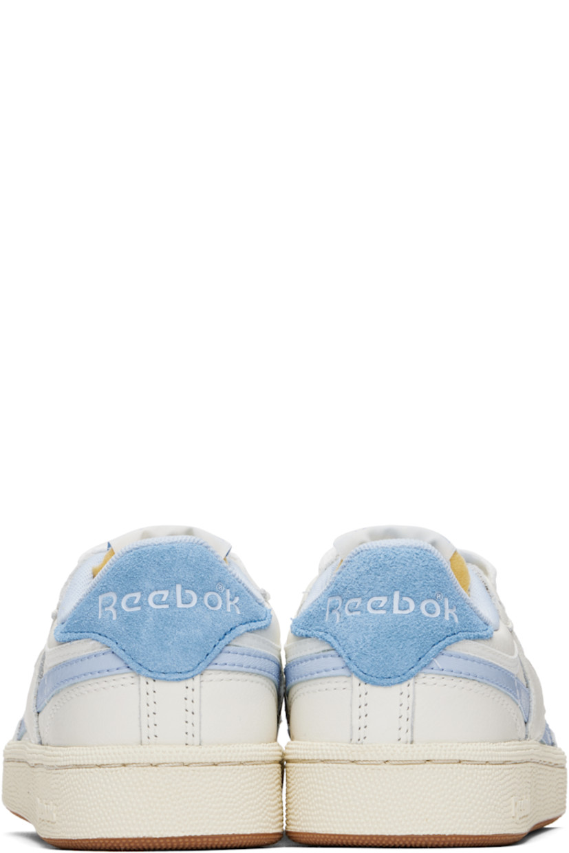Low-top grained leather sneakers in off-white and blue.

· Perforated detailing at toe
· Lace-up closure
· Logo patch at padded tongue
· Padded collar
· Inset logo patch at outer side
· Signature stripes at sides
· Logo embossed at suede heel tab
· Mesh lining
· Treaded rubber sole

Supplier color: Chalk/Y2kblue/Recoveryblue