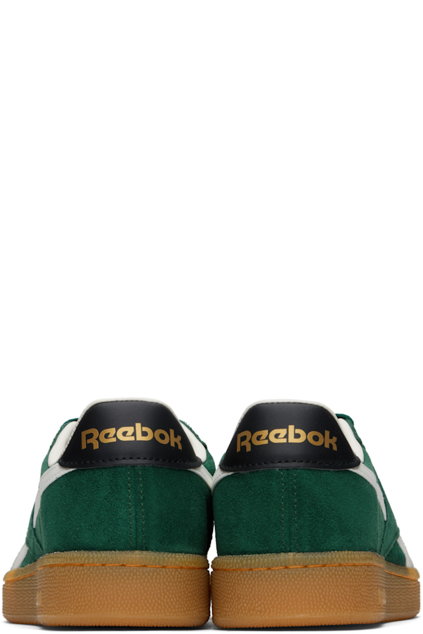 Low-top suede sneakers in green.

· Buffed leather trim throughout
· Perforations at toe
· Lace-up closure
· Logo embossed at padded tongue
· Padded collar
· Signature stripes at sides
· Inset logo patch at outer side
· Logo stamp at heel tab
· Buffed leather and mesh lining
· Treaded rubber sole

Supplier color: Collegiategreen/Black/Gum