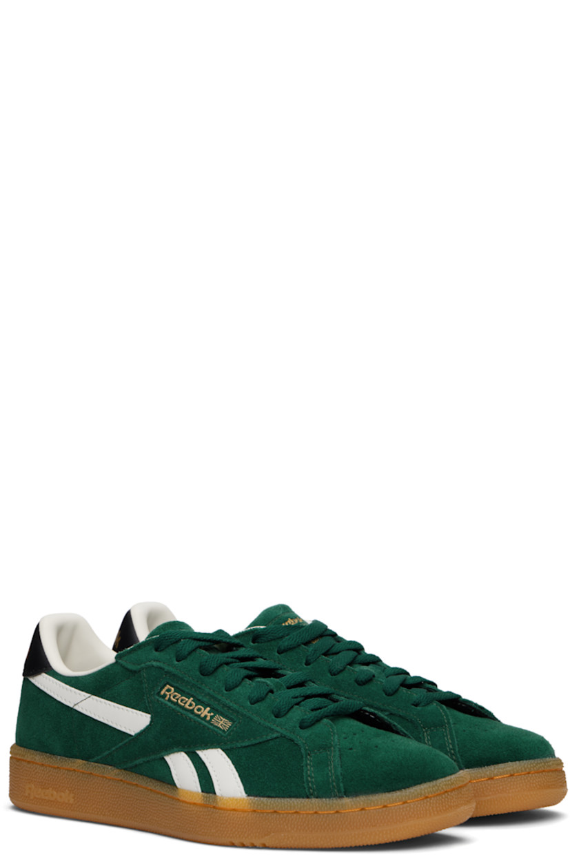 Low-top suede sneakers in green.

· Buffed leather trim throughout
· Perforations at toe
· Lace-up closure
· Logo embossed at padded tongue
· Padded collar
· Signature stripes at sides
· Inset logo patch at outer side
· Logo stamp at heel tab
· Buffed leather and mesh lining
· Treaded rubber sole

Supplier color: Collegiategreen/Black/Gum