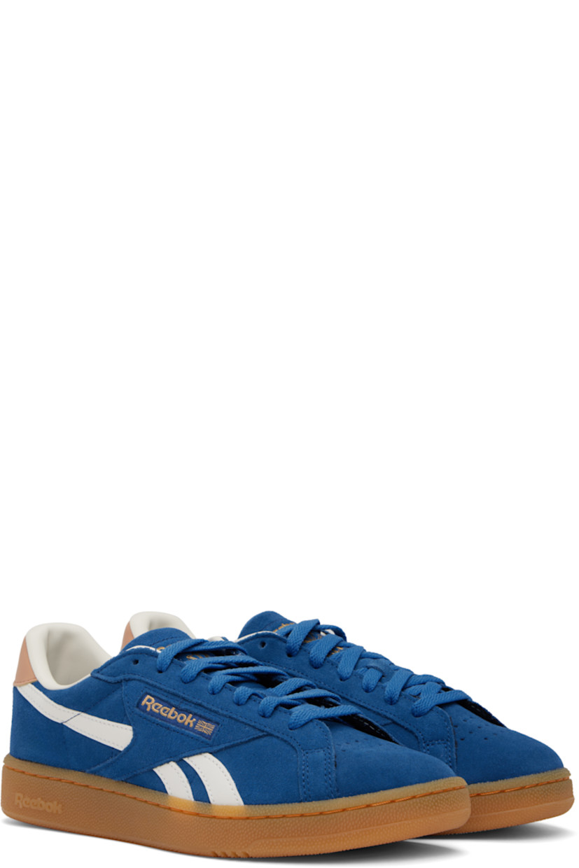 Low-top suede sneakers in blue.

· Buffed leather trim throughout
· Perforations at toe and inner side
· Lace-up closure
· Logo embossed at padded tongue
· Padded collar
· Inset logo patch at outer side
· Stripes at sides
· Logo printed at heel tab
· Buffed leather and mesh lining
· Logo embossed at crêpe-rubber midsole
· Treaded rubber sole

Supplier color: Twilight blue/Clay/Chalk