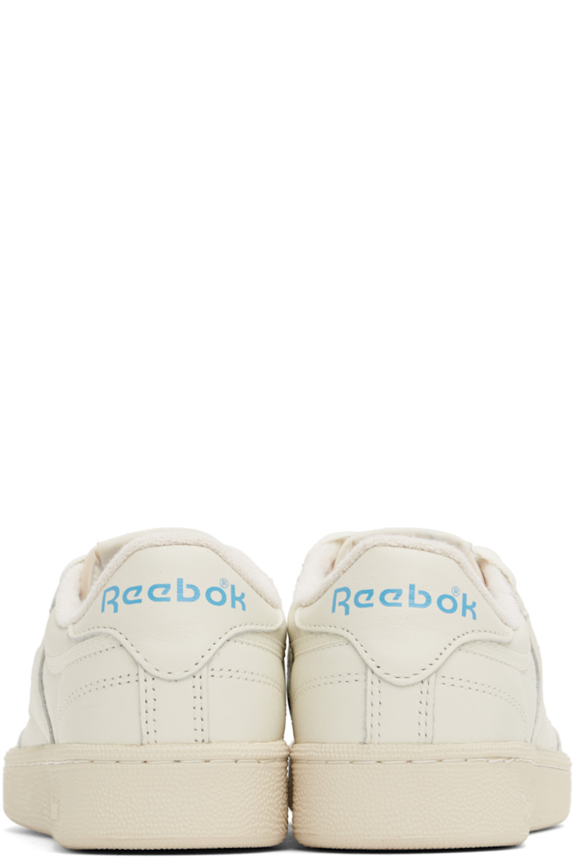 Low-top buffed leather sneakers in off-white.

· Perforated detailing at vamp
· Lace-up closure
· Logo patch at padded tongue
· Padded collar
· Inset logo patch at outer side
· Logo printed at heel tab
· Terry cloth lining
· Foam rubber midsole
· Treaded rubber sole

Supplier color: Chalk/Alabaster/Essential blue
