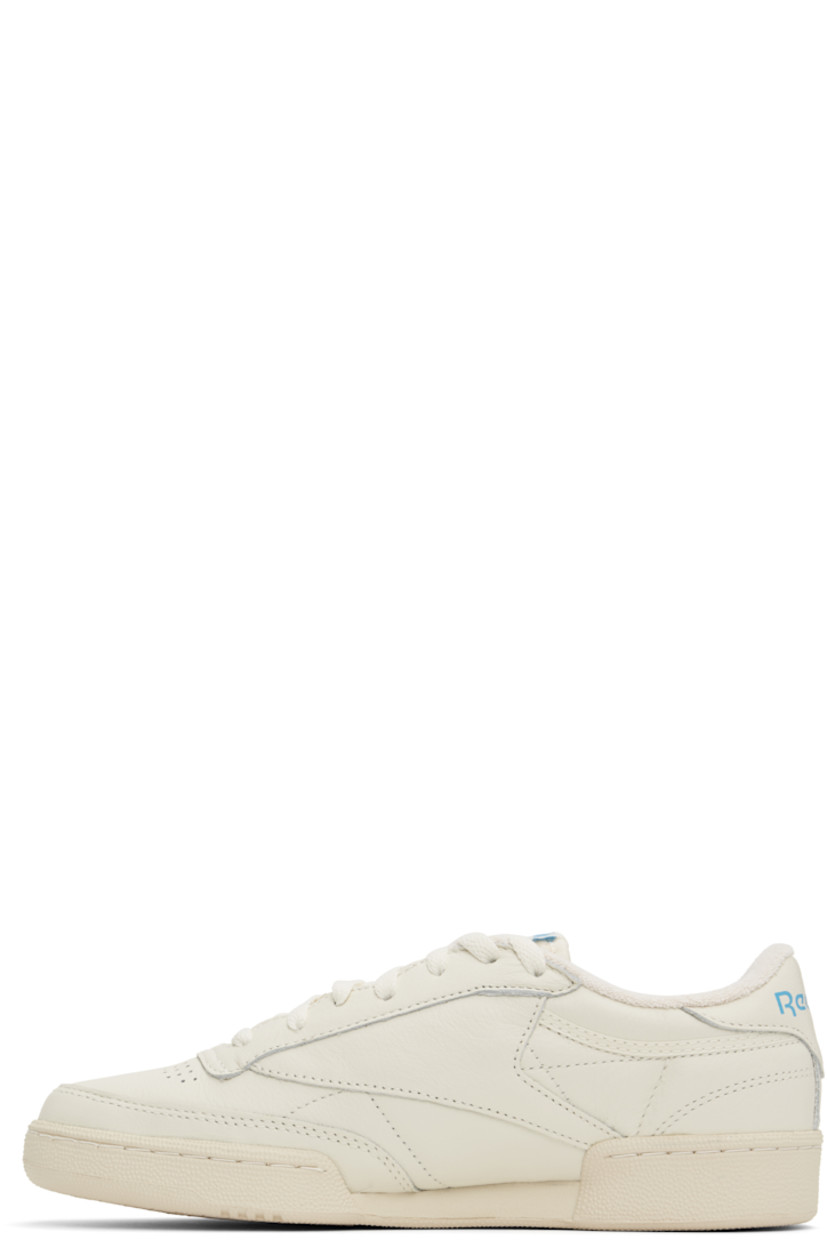 Low-top buffed leather sneakers in off-white.

· Perforated detailing at vamp
· Lace-up closure
· Logo patch at padded tongue
· Padded collar
· Inset logo patch at outer side
· Logo printed at heel tab
· Terry cloth lining
· Foam rubber midsole
· Treaded rubber sole

Supplier color: Chalk/Alabaster/Essential blue